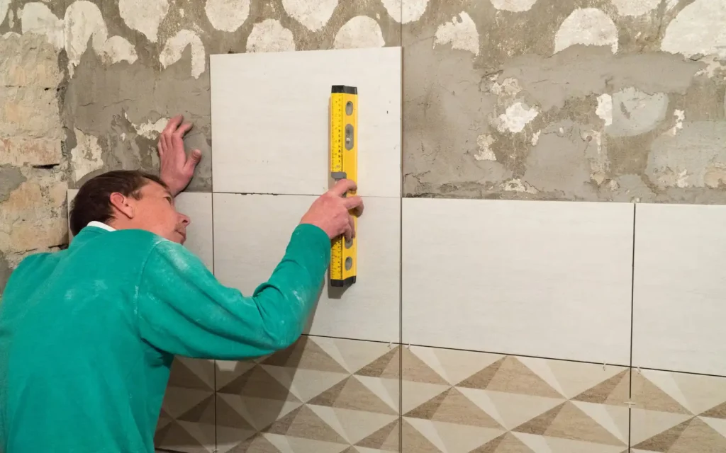 Portsmouth-bathroom-fitter-laying-bathroom-tiles-precisely-using-spirit-level